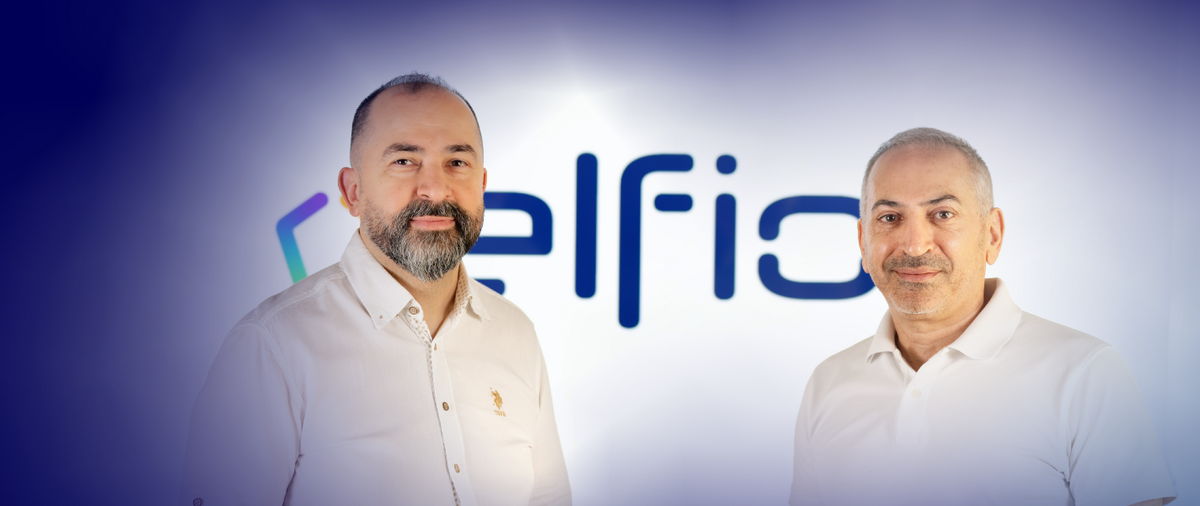 Zwei elfio-Teammitglieder vor dem elfio-Logo.